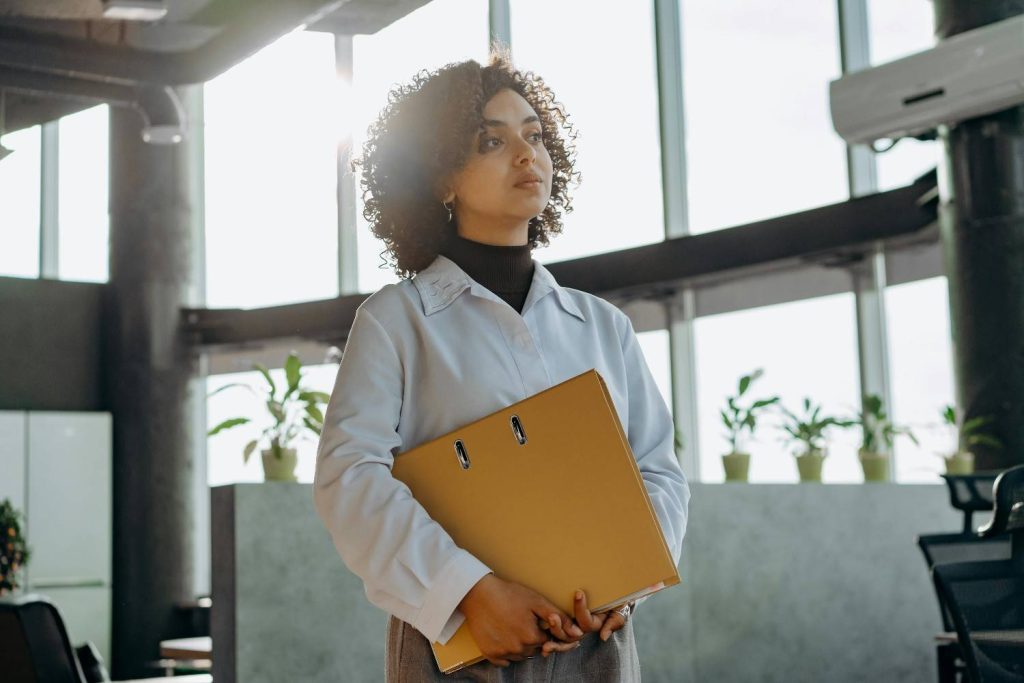 A thoughtful tech professional looking out a modern office window, symbolizing the emotional complexity and signs of a career change from Google into a new chapter. Signs You Need A Career Change.