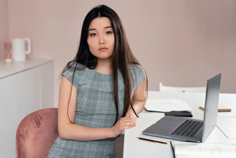 Professional woman looking thoughtful at her desk during a career transition. Why Career Transitions Feel So Unsettling for High Performers.
